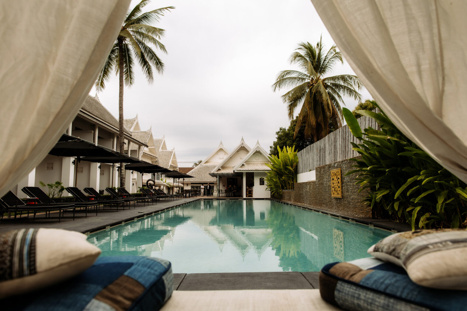Palm-fringed swimming pool at Souphattra Hotel Luang Prabang